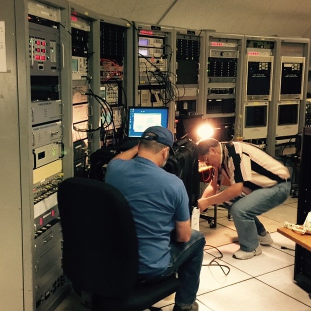 Zwei Personen arbeiten an einem Laptop in einem Generatorraum.