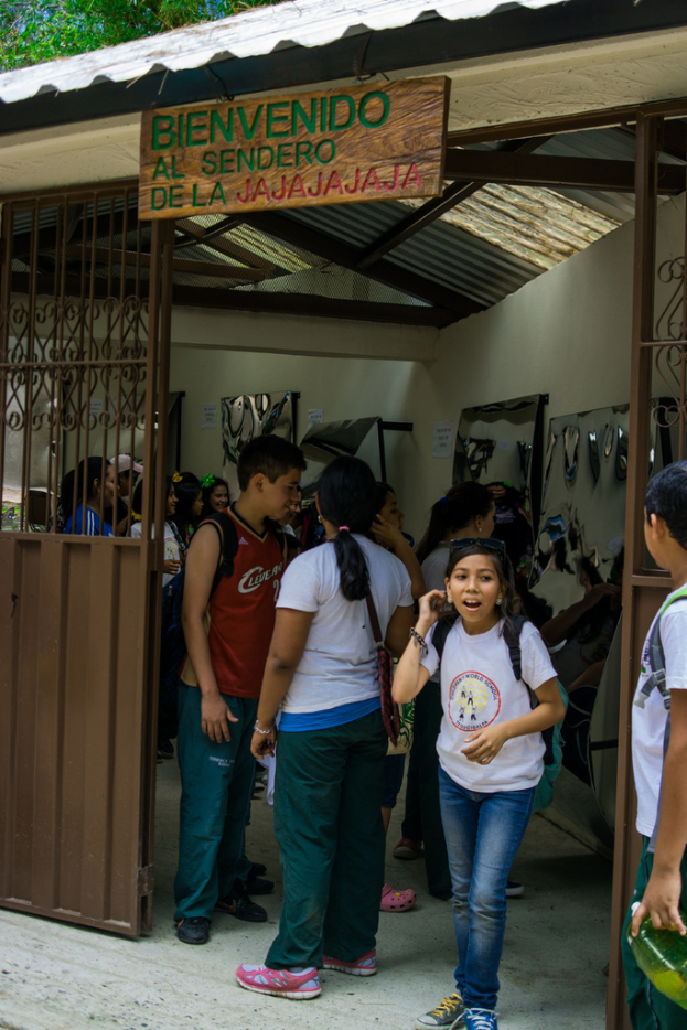 Ein Geschäft mit einem Blechdach, einem Schild oben mit Text und Menschen drinnen.