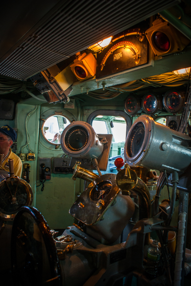 Das Innere eines Zuges mit Sitzen und verschiedenen Gegenständen, mit einer Person auf der linken Seite in einem gelben T-Shirt.