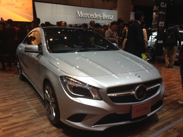 Mercedes-Benz CLA-Klasse Coupé auf der Shanghai Auto Show präsentiert, mit einem eleganten schwarzen Finish mit Chromakzenten und einem modernen, luxuriösen Innenraum, während Zuschauer das Design bewundern.
