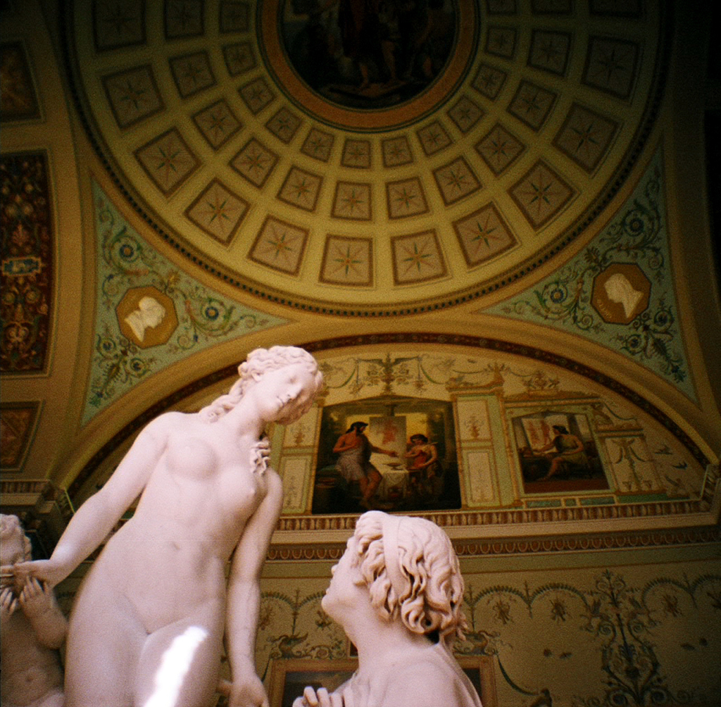 Skulpturen in der Mitte und auf der linken Seite eines Raumes mit Gemälden an der Hintergrundwand.