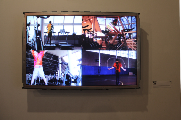 Ein an der Wand befestigter Fernseher mit Menschen, die Sport treiben.