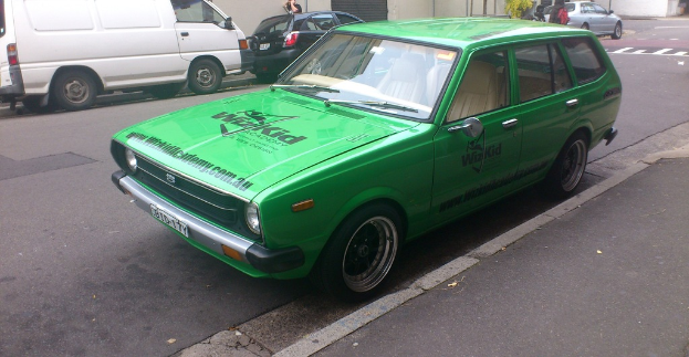 Eine Person in der Nähe einer Straße mit Fahrzeugen.