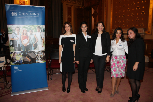 Ein Banner links, St├╝hle im Hintergrund, f├╝nf Frauen rechts und eine Wand im Hintergrund.