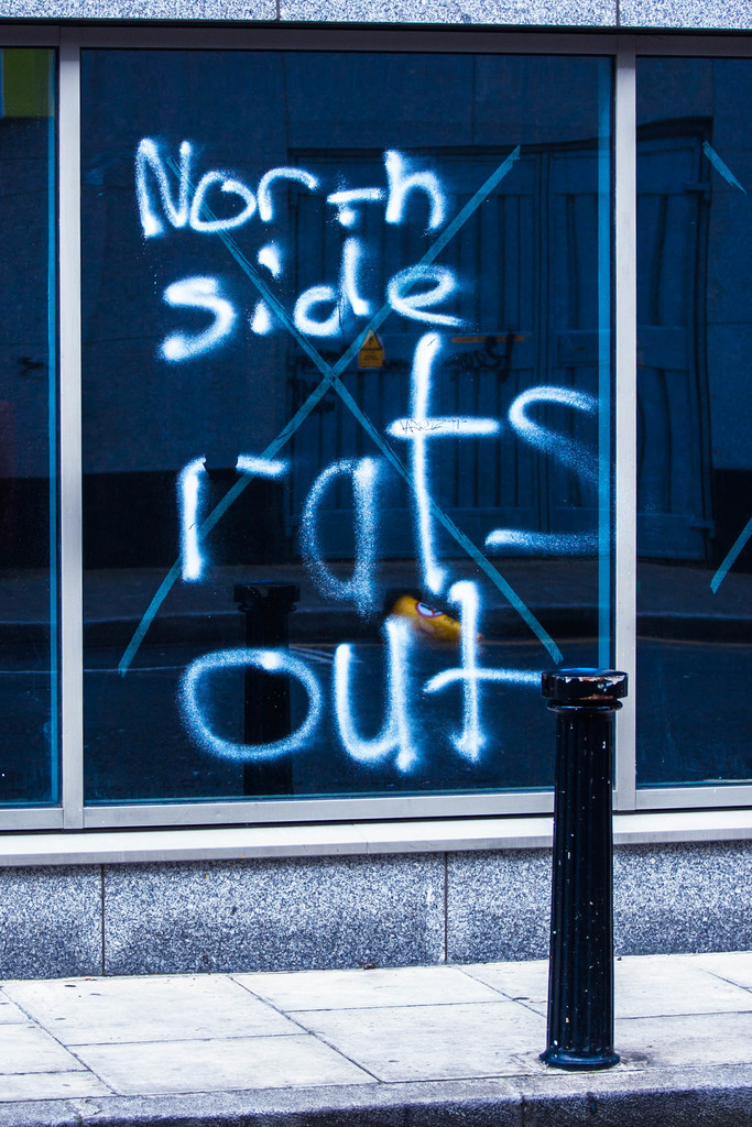 Text auf einem Fenster und eine Sperrstange auf der Straße.