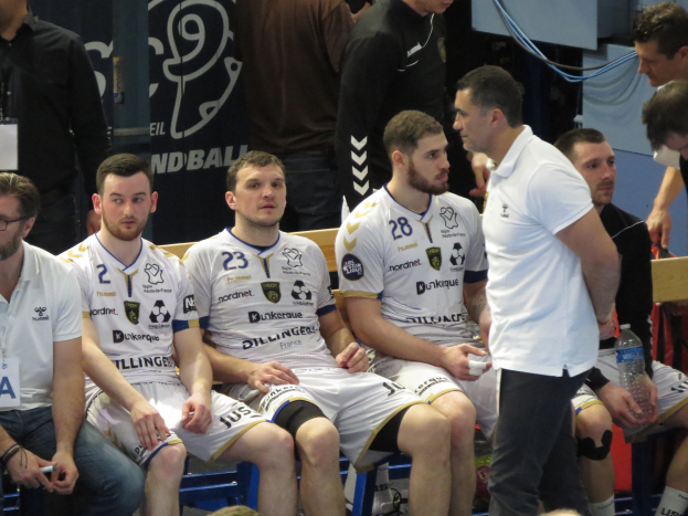 Eine Gruppe von Männern sitzt auf einer Bank, einige halten Flaschen, mit einem Banner im Hintergrund, das "Nordkraque vs Bordeaux" zeigt.