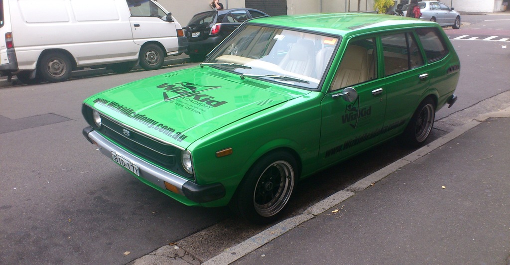 Eine Person steht in der Nähe einer Straße mit Fahrzeugen.