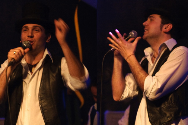 Eine Gruppe von Menschen mit zwei Personen, die in die Mikrofone singen.