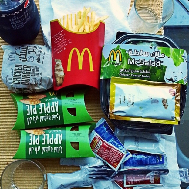 Ein Tisch mit Pommes, Keksen, Saucenbeuteln, einem Glas und Papiertüchern.