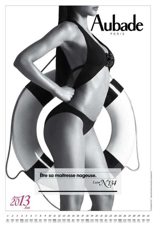 Eine Frau steht mit einem Röhrchen in der Hand, mit lesbarem Text und einem Datum in der linken unteren Ecke vor einem weißen Hintergrund.