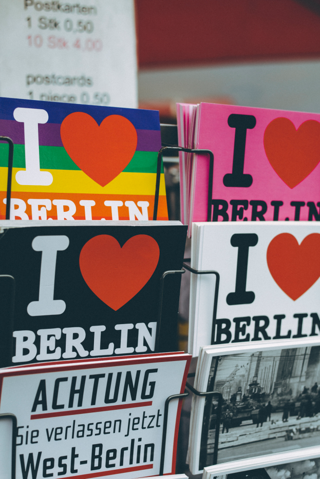 Ein Gestell mit verschiedenen Büchern und Plakaten mit der Aufschrift 'Ich liebe Berlin' vor einem sanft unscharfen Hintergrund.