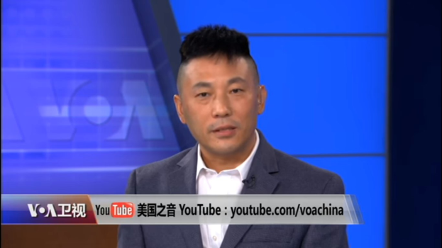 Ein chinesischer Nachrichtensprecher im Anzug und Krawatte auf einem Fernsehbildschirm mit blauem Hintergrund und Text unten.