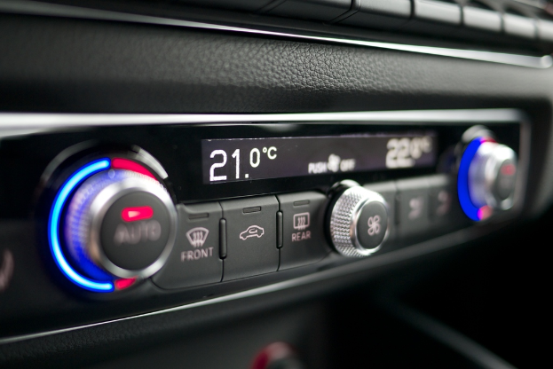 Eine Bedienkonsole mit mehreren Knöpfen, Reglern und Leuchten, mit Text in der Mitte.