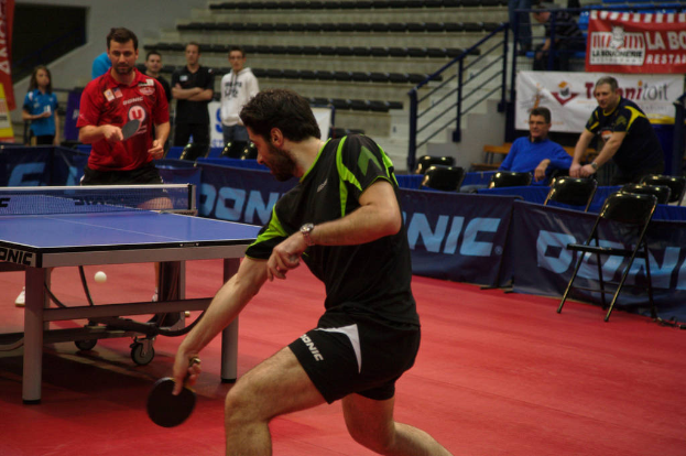 Eine Gruppe von Menschen in verschiedenen Farben, darunter schwarz, weiÃ und blau, versammelt sich um einen Tisch mit einem Spiel, StÃ¼hlen und einer Treppe im Hintergrund.