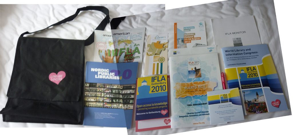 Eine Tasche mit den Worten "Bibliotheksliebhaber" und einigen Büchern auf einem Bett.