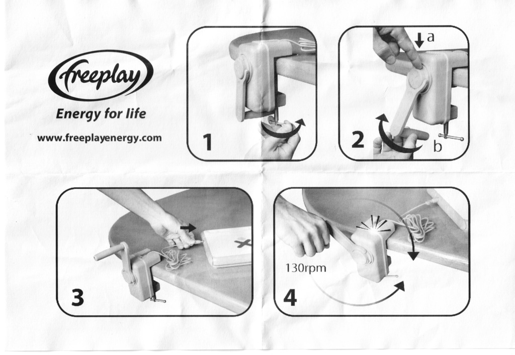 Eine Person hält ein Gerät, während ein weiteres Gerät und ein Kabel auf einem Tisch liegen, mit Text oben im Bild.