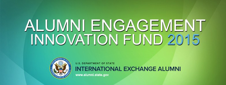 Grüner Hintergrund mit zentralem weißem Text, der "Alumni Engagement Innovation Fund 2015" lautet, und einem blauen Kreis-Logo mit weißer Umrandung und einem weißen Stern.