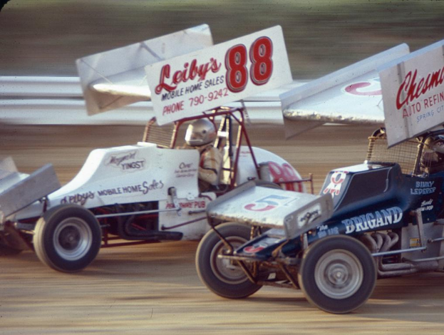 Mehrere Autos fahren auf einer Straße mit einer Sicherheitsbarriere am Straßenrand, mit einem unscharfen Hintergrund.