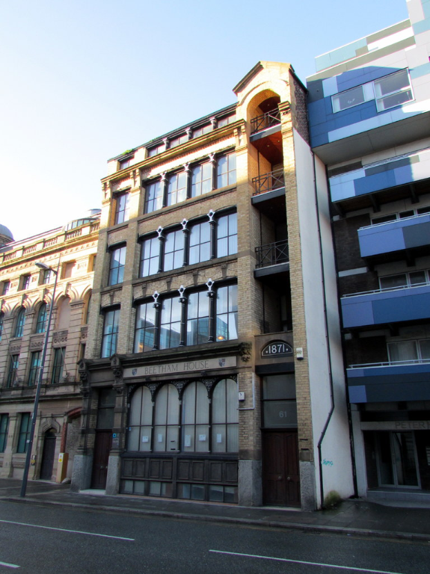 Mehrere Gebäude mit einem Pfahl in der linken Ecke und einer Straße davor.