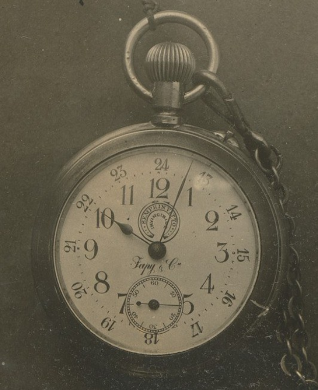 Altes Schwarz-Weiß-Foto einer Taschenuhr mit einer Kette, mit einer nummerierten Uhr.