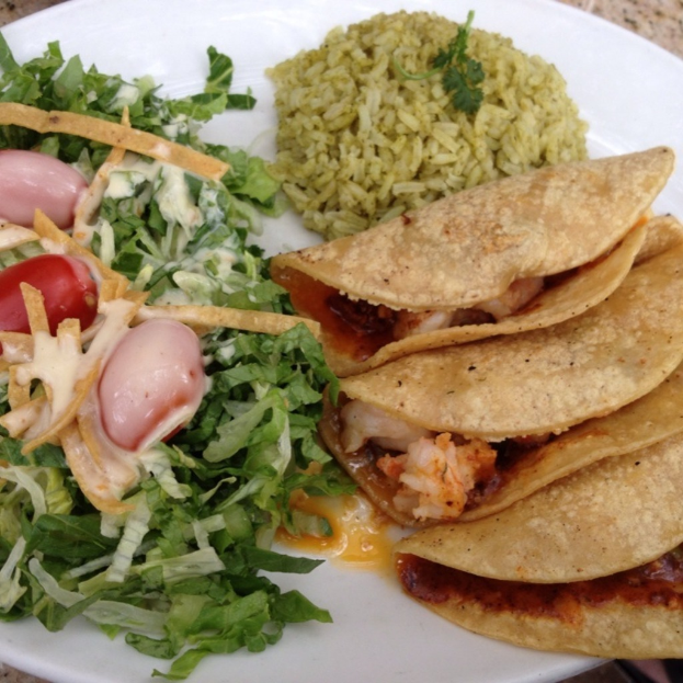 Ein weißer Teller mit Reis, Gemüse und Snacks.