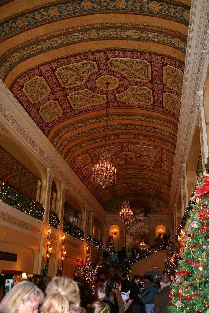 Eine Gruppe von Menschen, die zwischen Pflanzen mit Lampen und Leuchten an der Decke steht.