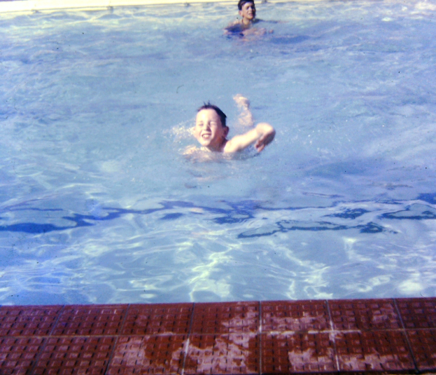 Zwei Kinder schwimmen in einem mit Wasser gefüllten Pool.