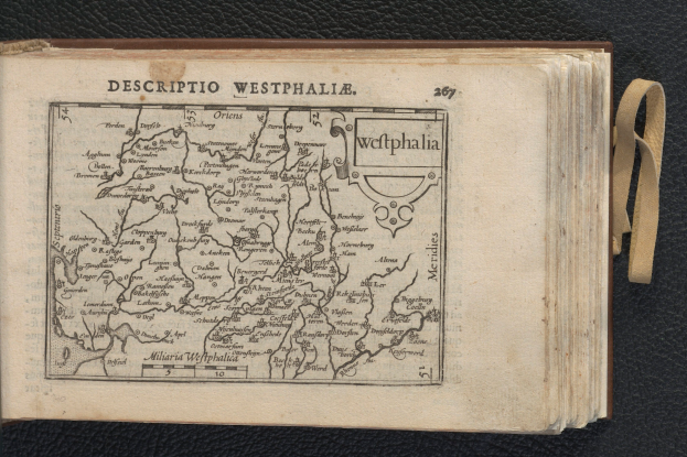 Ein aufgeschlagenes Buch mit einer detaillierten Landkarte von Westfalen auf einem schwarzen Untergrund.