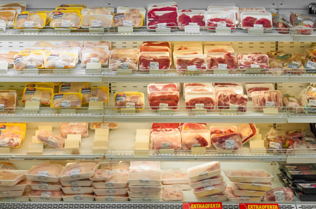 Ein gut organisierter Supermarkt-Fleischabteil mit verschiedenen Fleischsorten ordentlich auf Regalen angeordnet und mit Preisschildern versehen.