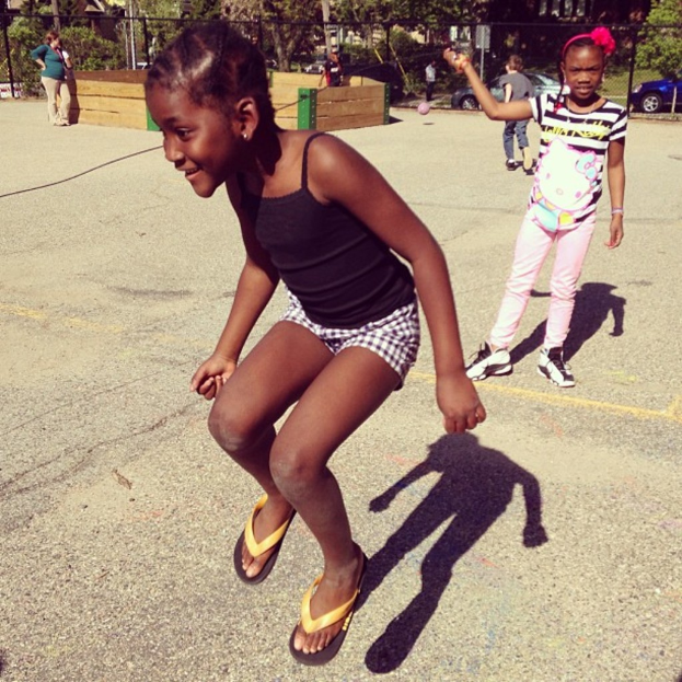 Eine wenig besiedelte Gegend mit einem Zaun, Bäumen und Autos im Hintergrund.