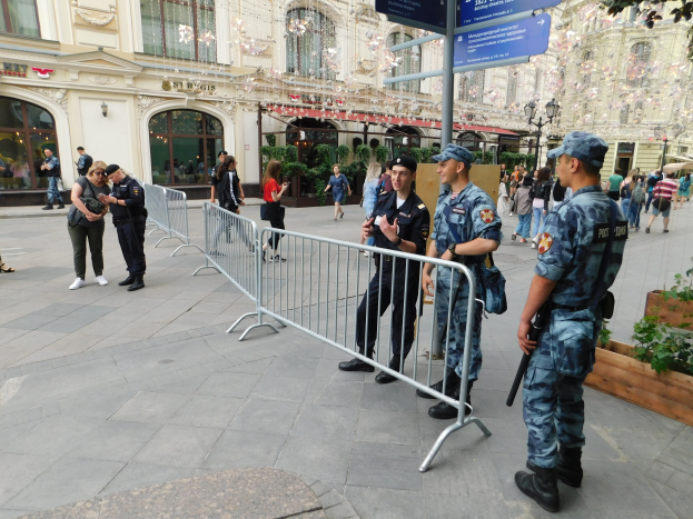 Polizeibeamte in Uniform hinter Barrikaden vor einer Menge stehend, einige mit Waffen, mit Gebäuden, Bäumen und Laternen im Hintergrund während einer Anti-Terror-Operation in Wien, Österreich.