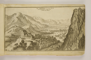 Ein aufgeschlagenes Buch mit einer detaillierten Illustration einer bergigen Landschaft, einschließlich grüner Bäume, verstreuten Häusern, hohen Hügeln und beschreibendem Text.