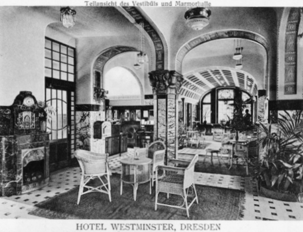 Die Lobby des Hotel Westminster in Dresden, Deutschland, mit Stühlen, Tischen, Pflanzen, Säulen, Uhr, Fenstern und Lichtern, mit Text am unteren Bildrand.