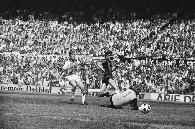 Schwarzes Foto von Fußballspielern im Einsatz auf einem Feld mit Zuschauern im Hintergrund und einer Bundesliga 1978-79 Ajax vs. Hannover 96 Tafel.